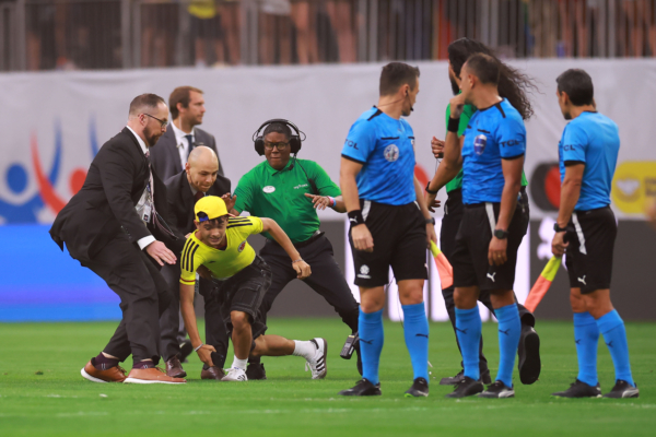 HOUSTON, TEXAS - JUNE 24: Members of security stop a pitch invader during the CONMEBOL Copa America 2024 Group D match between Colombia and Paraguay at NRG Stadium on June 24, 2024 in Houston, Texas. 